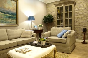 Ferienwohnung Zauberhaft - Einblick ins Wohnzimmer mit englischer Einrichtung, Sofa, Sessel und Stehlampe im Hintergrund